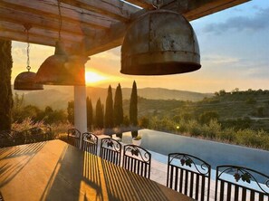 A terrace with a view of the sunset, a table with chairs, and a railing. - Soleevino B&B - Exclusively for Adults (Greve in Chianti)