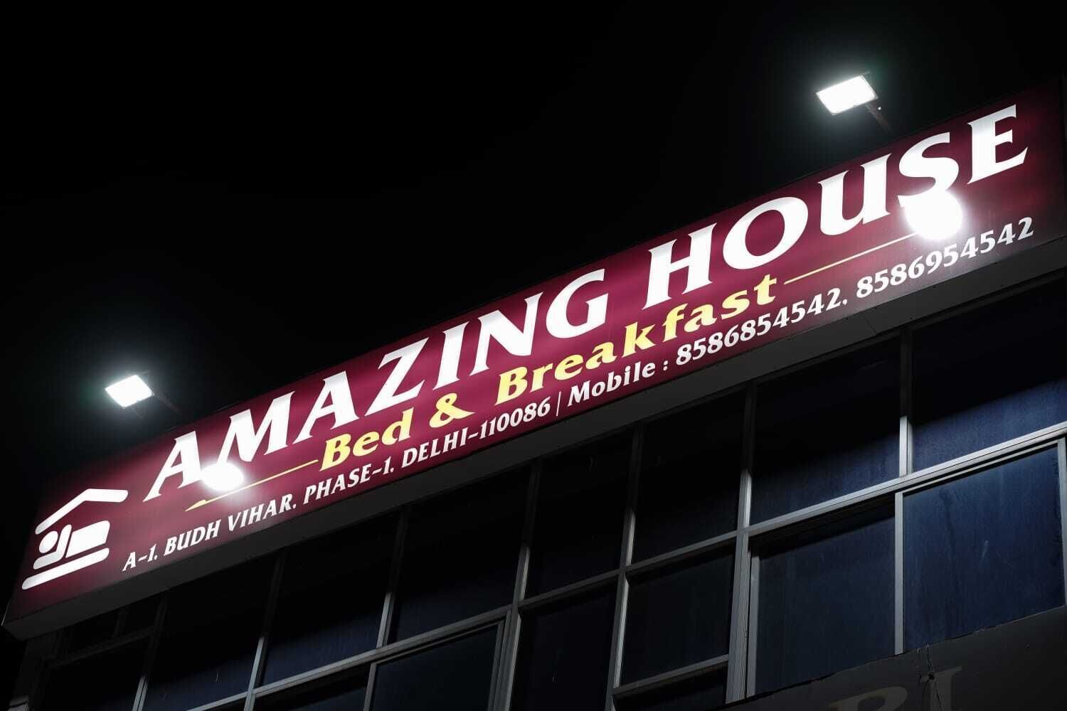 A sign for 'AMAZING HOUSE Bed & Breakfast' with contact information and location details.
