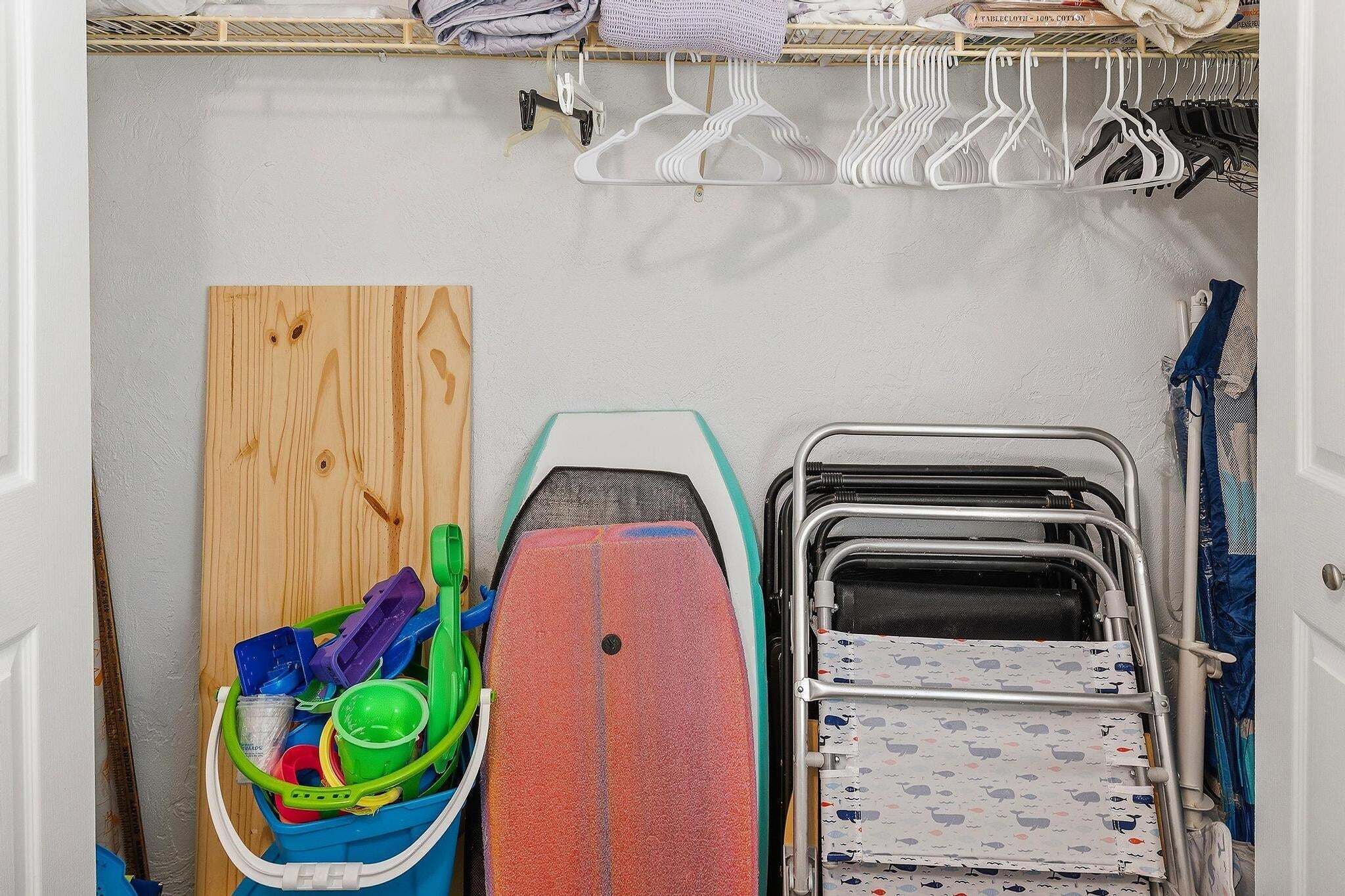 Un espace dédié à la lessive, avec une planche en bois, un seau coloré et un chariot en métal.