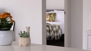 A modern kitchen with a white countertop, a small plant, and a decorative ceramic piece. - Bright & Stylish Terrace Retreat Richmond (Richmond)