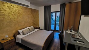 A hotel room with a bed, a desk, and a view of the outdoors. - Rooms and Apartment Matika (Rovinj)