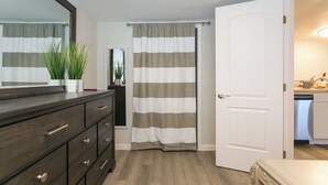 Ein Badezimmer mit einem Holzkapfen, einem gestreiften Duschvorhang und einer weißen Tür.