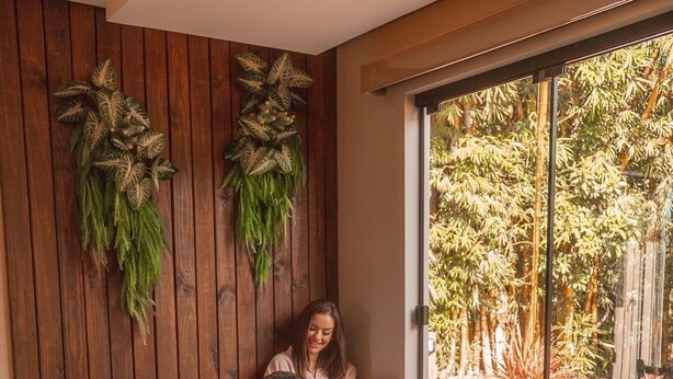 A couple relaxing in a hot tub with a view of a garden. - Pousada Recanto dos Canyons (Praia Grande)