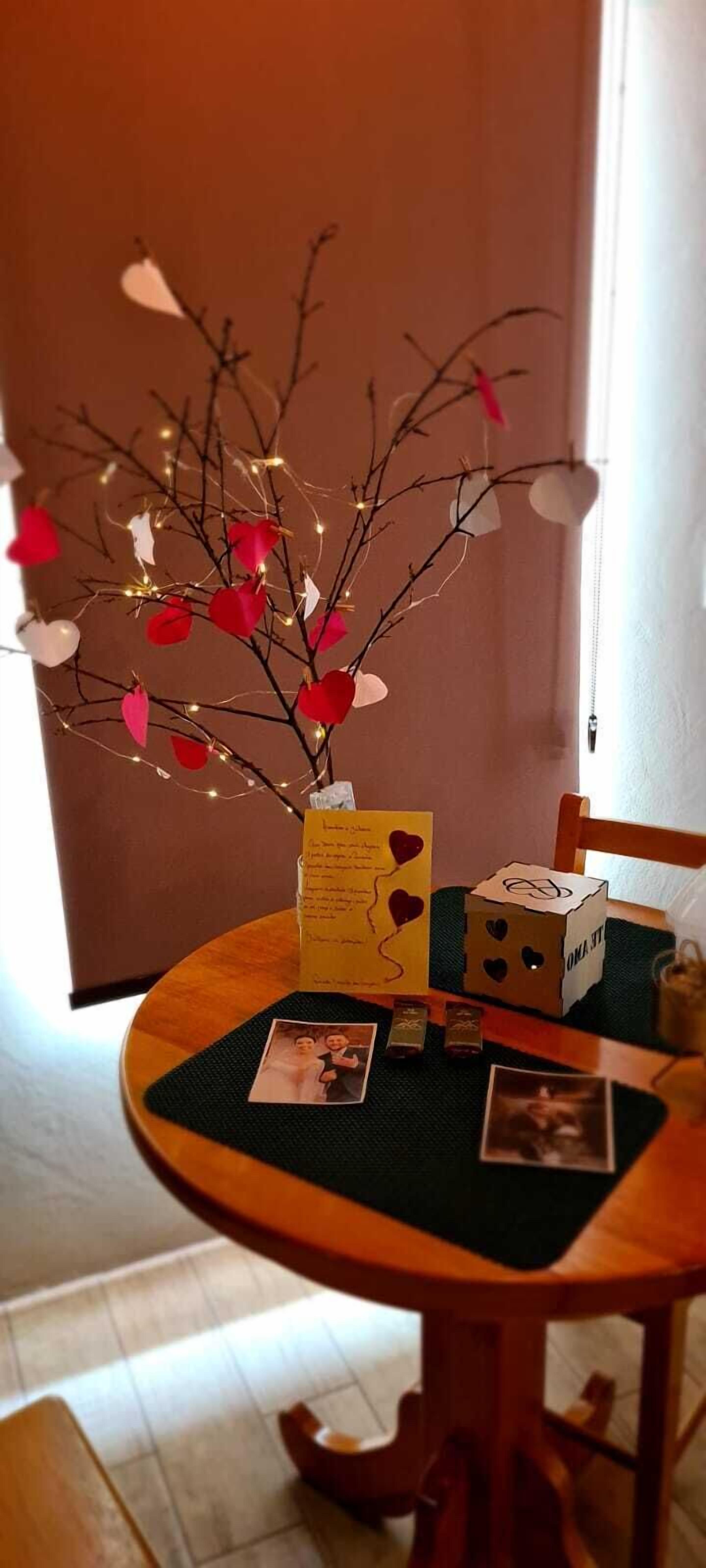 A dining table with a decorative centerpiece, a card, and a box.
