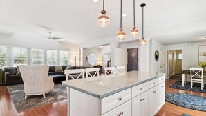 A spacious kitchen with a central island, white cabinetry, and pendant lighting. - Spacious 4 Bedroom, Sleeps 10. Walk everywhere! (Bethany Beach)