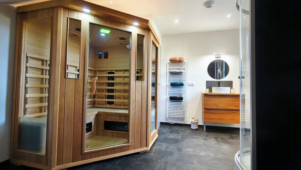 Une salle de bain moderne avec une douche à l’italienne en bois, un meuble-lavabo avec un miroir et des toilettes.