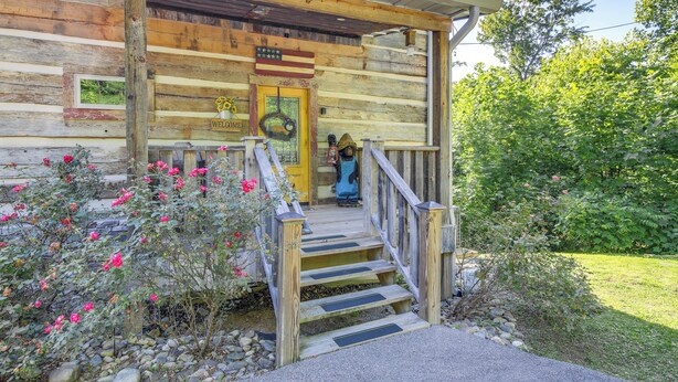 A wooden cabin with a porch, a welcome sign, and a wreath. - Hot Tub + Pool Table: 3-story Gatlinburg Cabin! (Gatlinburg)