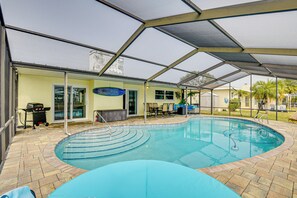 A covered swimming pool with a patio area, including a grill and seating. - Sunny South Daytona Home w/ Pool & Grill! (Daytona Beach)
