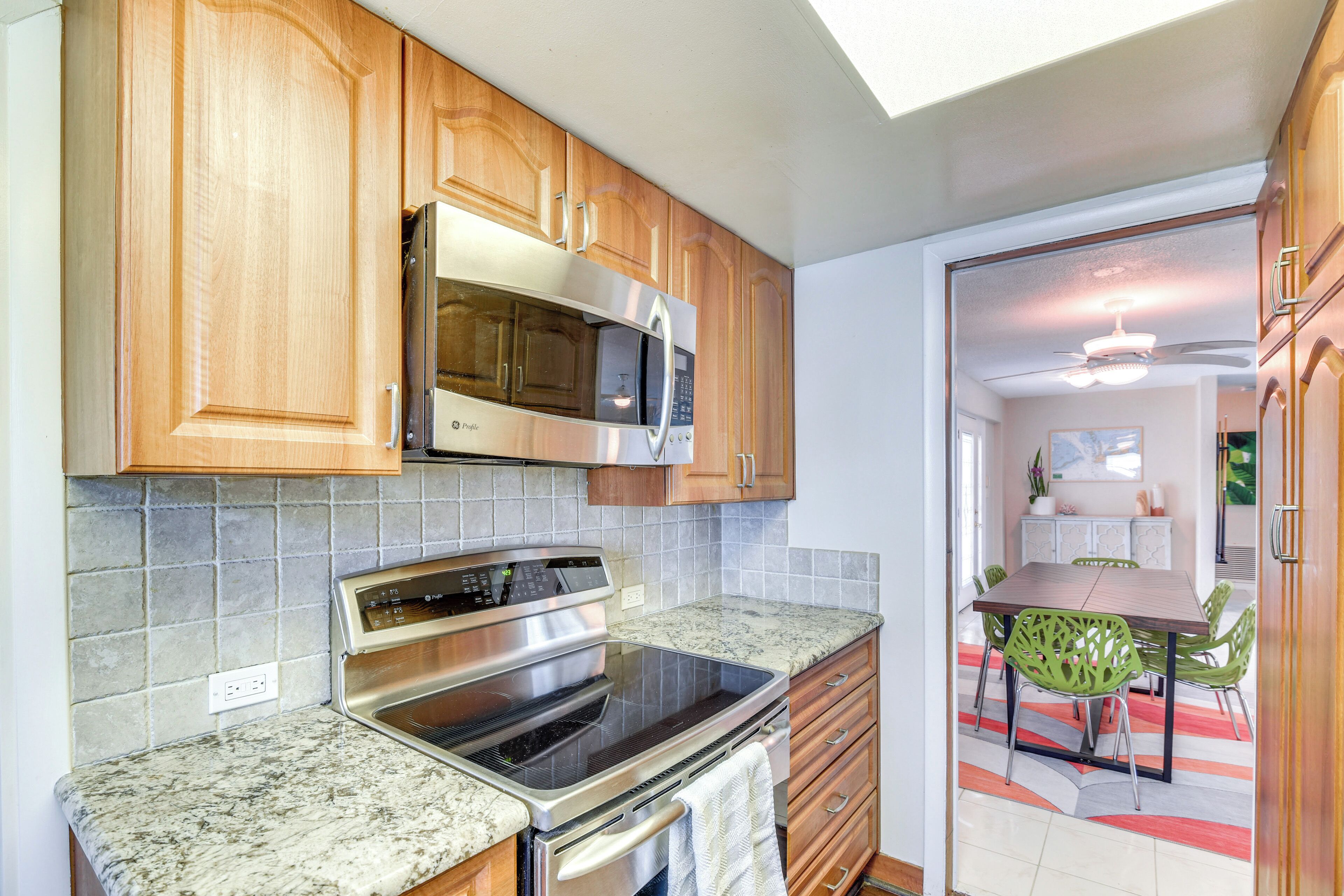 A kitchen with wooden cabinets, a stainless steel microwave, and a built-in oven.