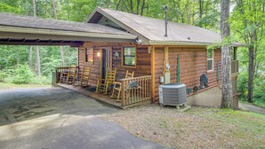 Eine Blockhütte mit Veranda, Sitzgelegenheiten im Freien und einem überdachten Bereich.