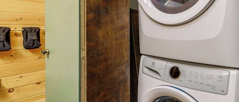 A laundry area with a washing machine and dryer stacked vertically.