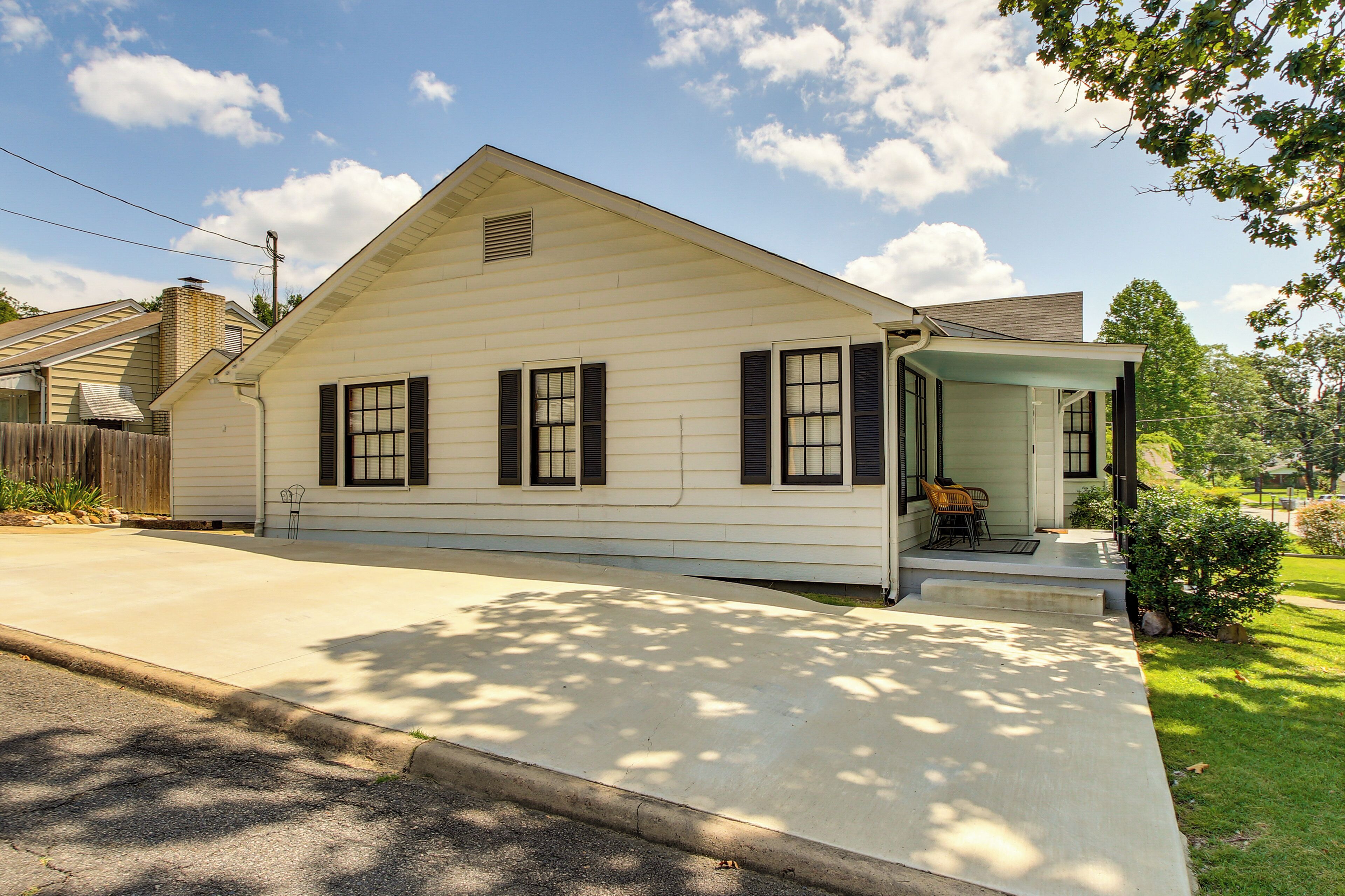 A single-story house with a front porch, a chimney, and a small front yard.