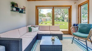 A modern living room with a sectional sofa, a wicker chair, and a coffee table. - 2 Mi to Dtwn Oshkosh: Canal Front w/ Dock! (Oshkosh)