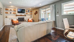 A living room with a sofa, chairs, a fireplace, and a TV. - 2 Mi to Dtwn Oshkosh: Canal Front w/ Dock! (Oshkosh)
