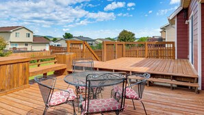 A wooden deck with metal chairs and a table, surrounded by a wooden fence. - Black Hills Family Home: Close to Hiking Trails! (Blackhawk)