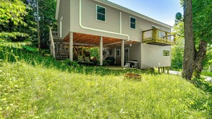 Une maison à deux étages dotée d’un patio couvert et d’une petite terrasse.