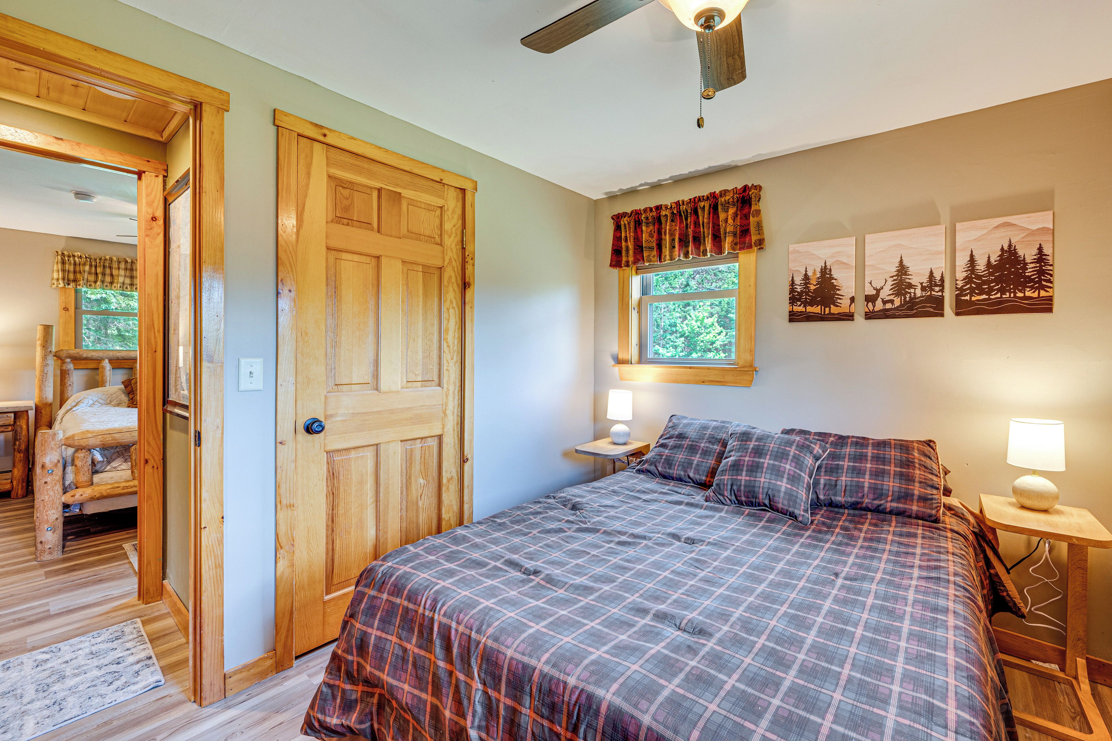 A bedroom with a large bed, wooden door, and a window with curtains.