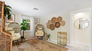 Une pièce meublée de meubles en osier, avec un tapis à motifs et des décorations murales.