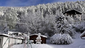 A snow-covered landscape with a wooden cabin and a swing set. - UPSTAIRS, 2 BEDROOMS APARTMENT - small room with double bed (Bad Bleiberg)