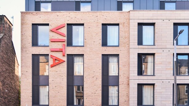 Ein modernes Gebäude mit einem gut sichtbaren 'VITA'-Schild an der Fassade.