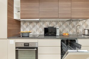 Apartamento, 2 quartos, sacada | Cozinha privada | Geladeira, micro-ondas, fogão, cooktop