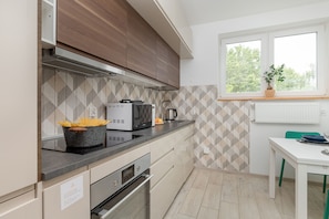 Apartamento, 2 quartos, sacada | Cozinha privada | Geladeira, micro-ondas, fogão, cooktop