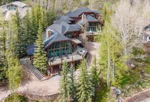A large, multi-story log cabin with a wrap-around deck, surrounded by dense forest. - Private House with Hot Tub in Vail, 796APP (Vail)