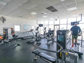 Ein Fitnessstudio mit Laufbändern, Crosstrainern und Gewichten.