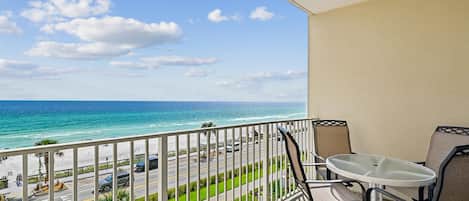 A balcony with a view of the ocean and a street.