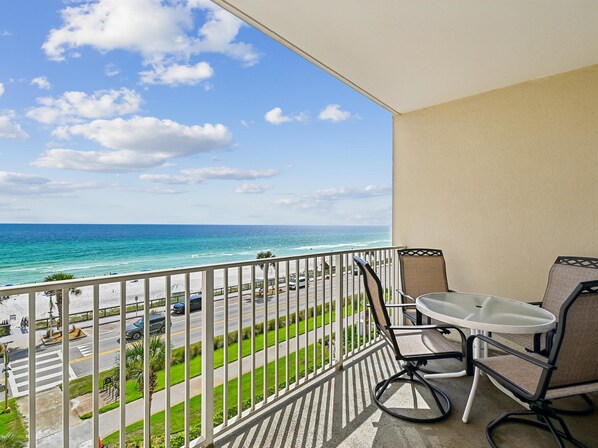 A balcony with a view of the ocean and a street.