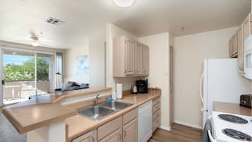 Una cocina moderna con una isla grande, pileta de acero inoxidable y muebles de madera.