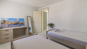 Un dormitorio con cama, escritorio, silla y un espejo grande.