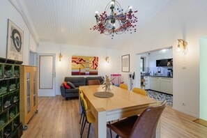 Enjoy meals in the central dining area with a wooden table and comfortable seating.