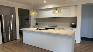 A modern kitchen with a central island, stainless steel appliances, and pendant lighting. - Nagambie Lakes: 5  BR, 2  BA House in Nagambie, Sleeps 10 (Nagambie)