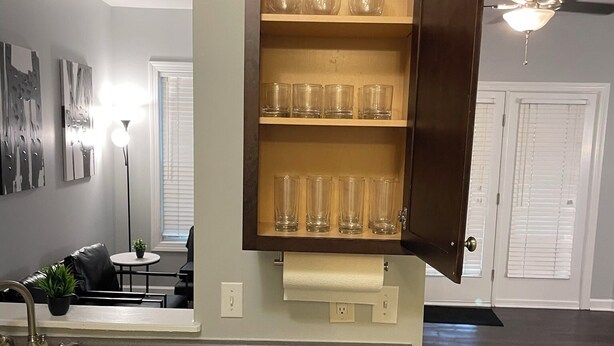 A kitchen with a built-in dishwasher, a countertop sink, and a cabinet with glassware. - Charming 2-bedroom townhome in wonderful Raleigh with WiFi, AC (Raleigh)