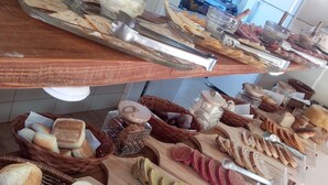Ein Buffet mit verschiedenen Brotsorten, Gebäcken und Fleischwaren.