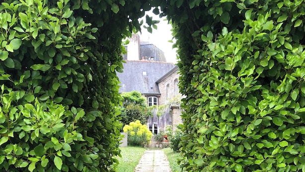 A stone staircase leading to a building, surrounded by lush greenery.