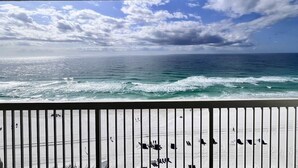 En balkon med udsigt over havet og gelænder af træ.
