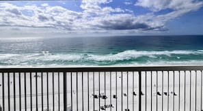 A balcony with a view of the ocean and a wooden railing. - Beachfront Resort-Amazing View-3 Pools/Tiki Bar (Destin)