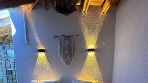 A cozy bedroom with a large bed, two wall-mounted lights, and a decorative macrame piece above the bed. - Lalekar Butik Otel (Ayvalik)