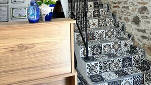 A staircase with patterned tiles, a wooden desk, and a metal railing. - Lalekar Butik Otel (Ayvalik)