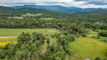 Experience the serene beauty of rolling hills, dense forests, and lush green fields in a secluded natural environment.