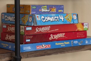 A stack of board games including Connect 4, Scrabble, and Monopoly. - Grand Chalet At Grand Lake 4 Bedroom Cabin by RedAwning (Grand Lake)