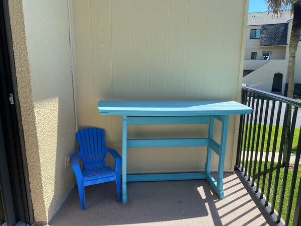 A balcony with a blue chair and a blue table. - Oceanview 2 Bedroom Town House (St. Augustine)