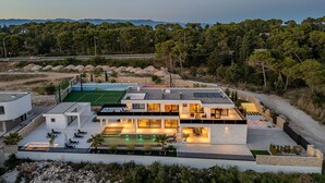 Uma casa moderna com piscina, área de estar externa e vista para a paisagem ao redor.