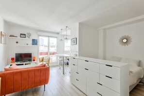 Um apartamento moderno com sala de estar, área de jantar e um quarto.