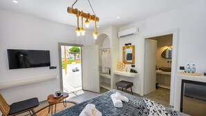 Ein modernes Hotelzimmer mit Bett, Fernseher, Schreibtisch und Bad.