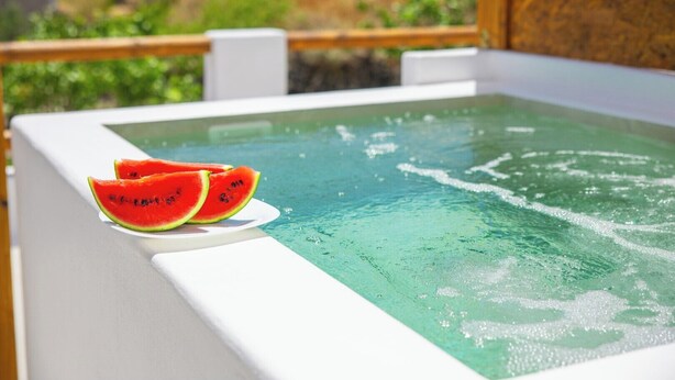 Ein Whirlpool mit klarem Wasser und zwei Wassermelonenscheiben am Rand.