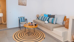 Ein modernes Wohnzimmer mit einer Couch, einem runden Couchtisch und einem gemusterten Teppich.
