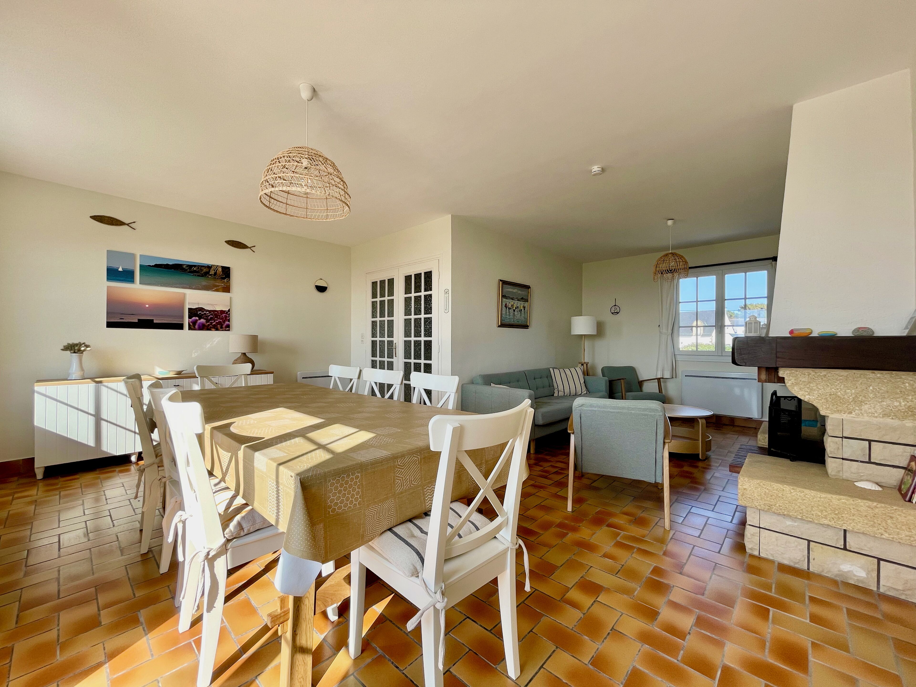 A spacious living area with a dining table, chairs, a sofa, and a fireplace.